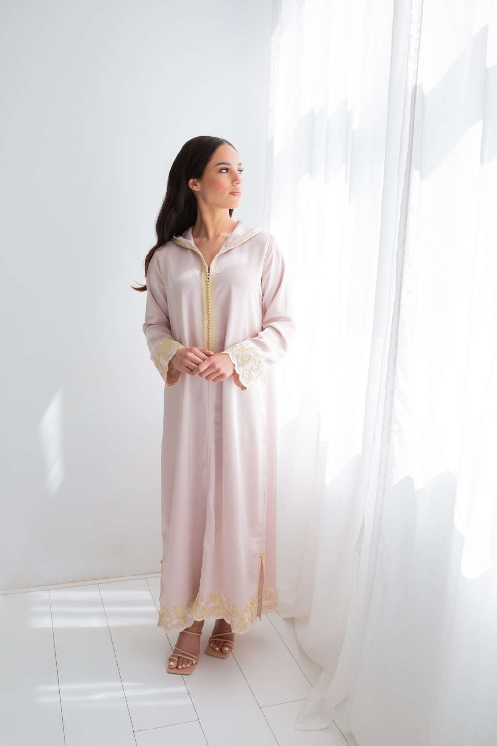 Femme en djellaba rose avec broderies dorées